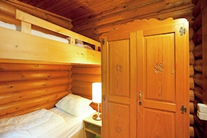 A wooden cabin room with a bunk bed, a wooden wardrobe, and a bedside table with a lamp. - Spacious Chalet near Ski Slopes in Worgl (Woergl)
