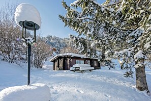 A snow-covered cabin with a picnic table in front, surrounded by trees and a clear sky. - Spacious Chalet near Ski Slopes in Worgl (Woergl)
