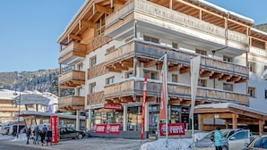 A multi-story hotel with wooden balconies and a ski resort sign. - Apartment in Gerlos Near Ski Lift (Gerlos)