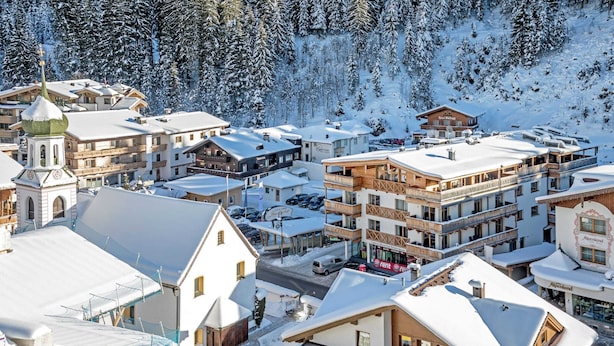 A snow-covered town with multiple buildings, including a church with a dome, a hotel, and several residential buildings. - Apartment in Gerlos Near Ski Lift (Gerlos)