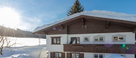 A chalet-style building with a sloped roof, wooden exterior, and multiple windows.