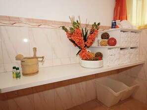 Bathroom features a bathtub, countertop, and storage for toiletries.