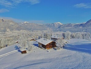 A snow-covered mountain village with wooden cabins and a clear blue sky. - Cozy Chalet in Sankt Johann in Tirol near Ski Area (Sankt Johann in Tirol)