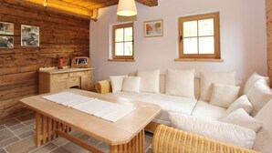 A cozy room with a wooden ceiling, a white sofa, a wooden table, and two windows. - Cozy Chalet in Sankt Johann in Tirol near Ski Area (Sankt Johann in Tirol)