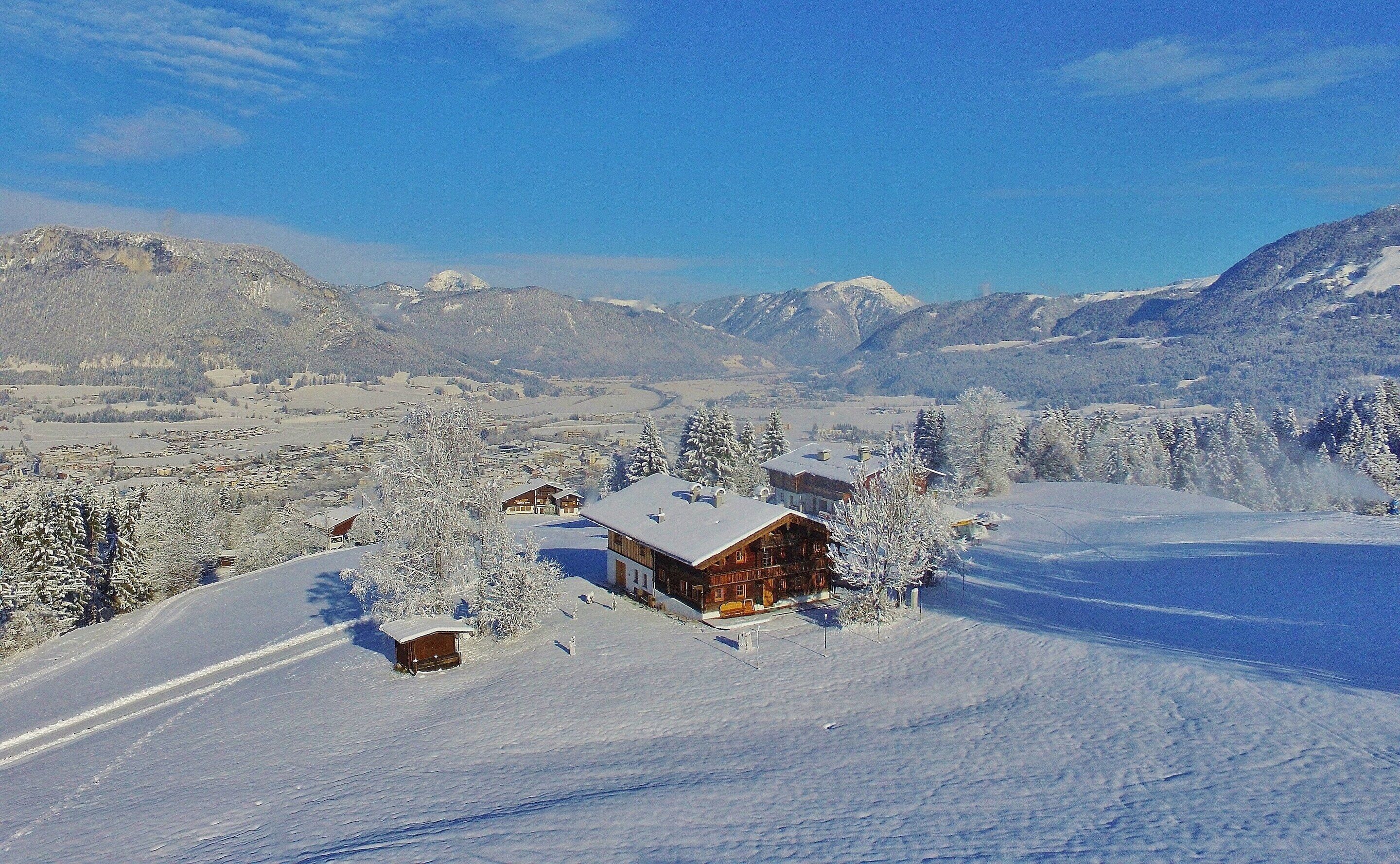 A snow-covered mountain landscape with wooden cabins.