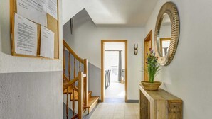 A hallway with a wooden staircase, a bulletin board, a mirror, and a star-patterned floor. - Luxury Holiday Home in Brixen im Thale Near Ski Area (Brixen im Thale)