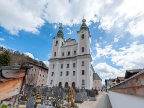 A church with two towers and a cemetery in front. - Penthouse With Steam Bath (Brixen im Thale)