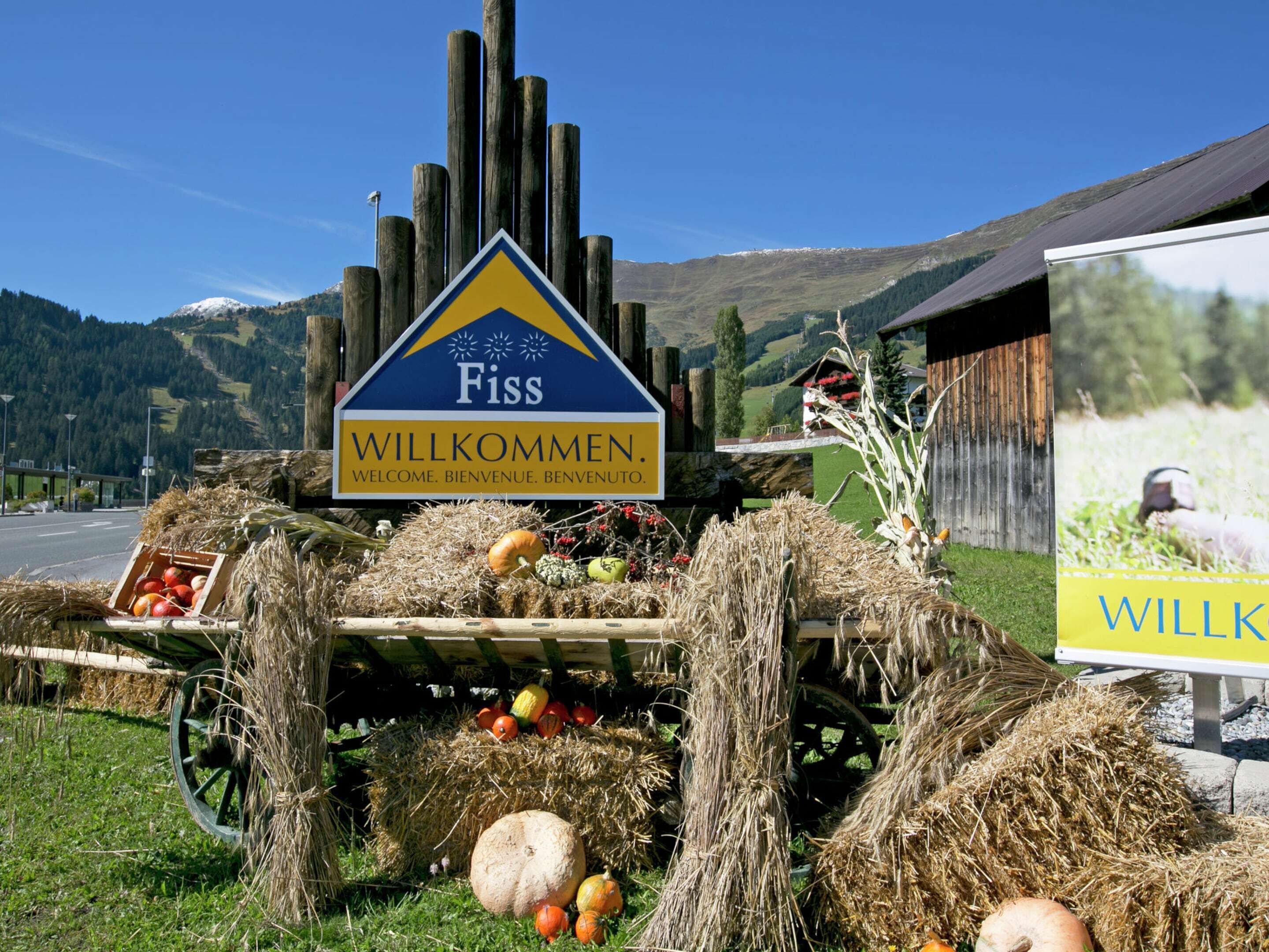 Welkomstbord voor Fiss, met een schilderachtige berg op de achtergrond.