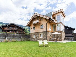 Een houten huis met twee verdiepingen, een stenen fundering, een balkon en een groot raam.