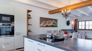 A modern kitchen with white cabinetry, a built-in oven, a microwave, and a granite countertop. - Apartment With Sauna and Ski In/out (Mittersill)