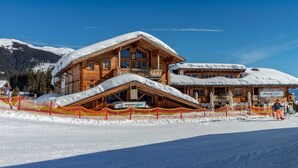 A wooden chalet with a sloped roof, a balcony, and a sign for 'Restaurant Moon Alm'. - Apartment With Sauna and Ski In/out (Mittersill)