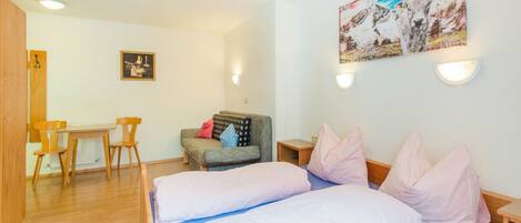 A room with a bed, a desk, and a chair.