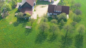 An aerial view of a rural property with two main buildings, a large barn, and surrounding green fields. - Apartment in Neuhaus Near Petzen Ski Area (Neuhaus)