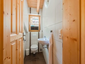 Ein kleines Badezimmer mit Toilette, Waschbecken und Fenster.
