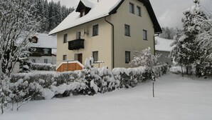 A two-story house with a snow-covered roof and a balcony. - Scenic Holiday Home in Deutsch Griffen near Hochrindl (Deutsch-Griffen)