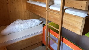 Ein Etagenbett mit zwei Schlafstellen, jeweils mit einer Matratze und Kissen.