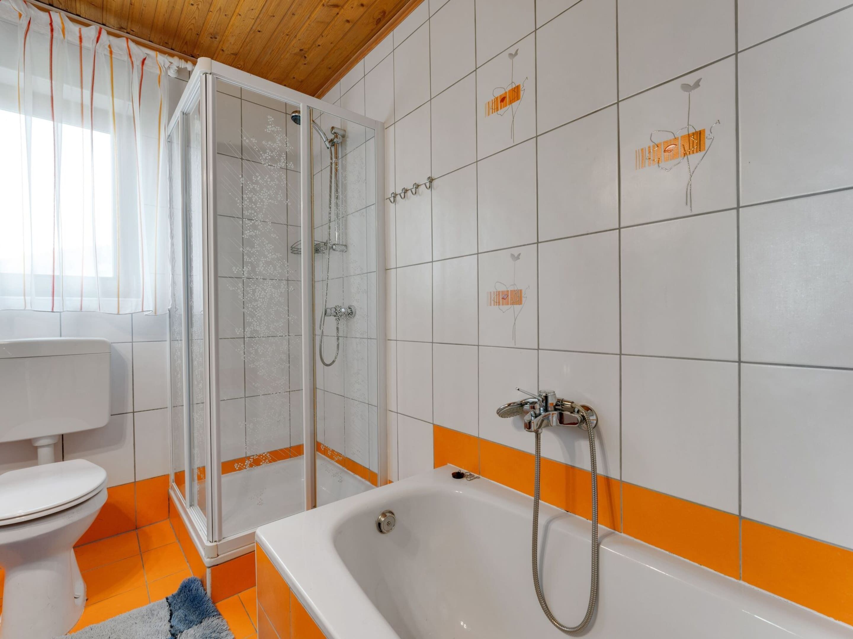 A bathroom with a shower, toilet, and bathtub.
