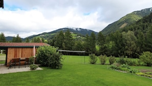 A rural property with a wooden building, a lawn, and a mountain backdrop. - Apartment in Katschberg Near Ski Slopes (Rennweg am Katschberg)