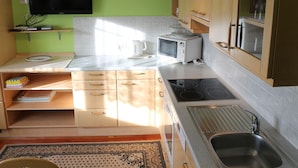A compact kitchen with a flat-screen TV, a microwave, a kettle, and a sink. - Apartment in Katschberg Near Ski Slopes (Rennweg am Katschberg)