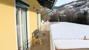 A yellow building with a balcony overlooking a snowy landscape and mountains. - Apartment in Katschberg Near Ski Slopes (Rennweg am Katschberg)