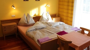 A bedroom with a bed, bedside tables, a desk, and a chair. There are wall-mounted lights and a window with curtains. - Apartment in Katschberg Near Ski Slopes (Rennweg am Katschberg)