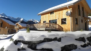 A wooden chalet with a balcony, set against a snowy mountain backdrop. - Wooden Chalet in Hohentauern With Sauna (Hohentauern)