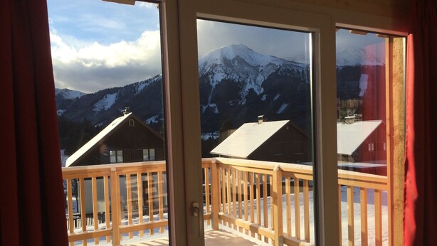 A balcony with a wooden railing overlooking a snowy mountain landscape. - Nice Chalet in Hohentauern / Styria With Sauna (Hohentauern)