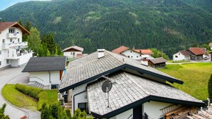 A residential area with houses, a paved road, and a mountain backdrop. - Apartment in Strengen Near Ski Bus (Strengen)