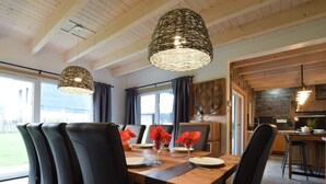 Ein Essbereich mit einem Holztisch, schwarzen Stühlen und zwei Pendelleuchten.