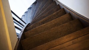 Un escalier en bois à la forme incurvée, qui monte.