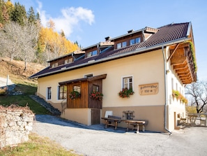 A traditional chalet with a wooden facade, a sign indicating elevation, and outdoor seating. - Holiday Home in Obervellach Near ski Area (Obervellach)