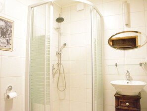 A bathroom with a glass shower enclosure, a white sink, and a mirror above it. - Holiday Home in Viroinval With Sauna (Viroinval)