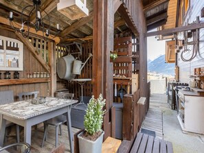 Ein rustikales Holzinterieur mit Essbereich, Küche und Sitzgelegenheiten im Freien.