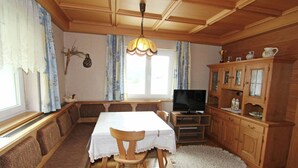 A cozy dining area with a wooden table, chairs, and a television. - Cozy Apartment in Ausservillgraten (Ausservillgraten)