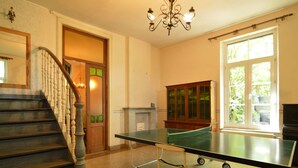 A room with a ping pong table, a staircase, and a cabinet. - Family Villa in Ferrieres (Ferrieres)