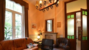 A cozy living room with a leather sofa, a wooden coffee table, and a fireplace. - Family Villa in Ferrieres (Ferrieres)
