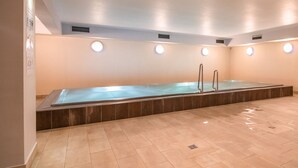 Ein großer, überdachter Pool mit Fliesenboden und ebener Decke mit integriertem Licht.