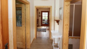 A wooden hallway with a white table and a hanging light fixture. - Peaceful Cottage near Ski Area in Gmünd (Gmuend in Kaernten)