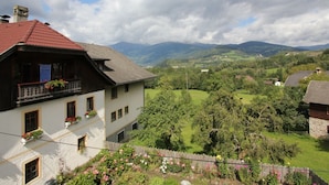 A traditional chalet with a balcony, surrounded by lush greenery and mountains in the background. - Peaceful Cottage near Ski Area in Gmünd (Gmuend in Kaernten)