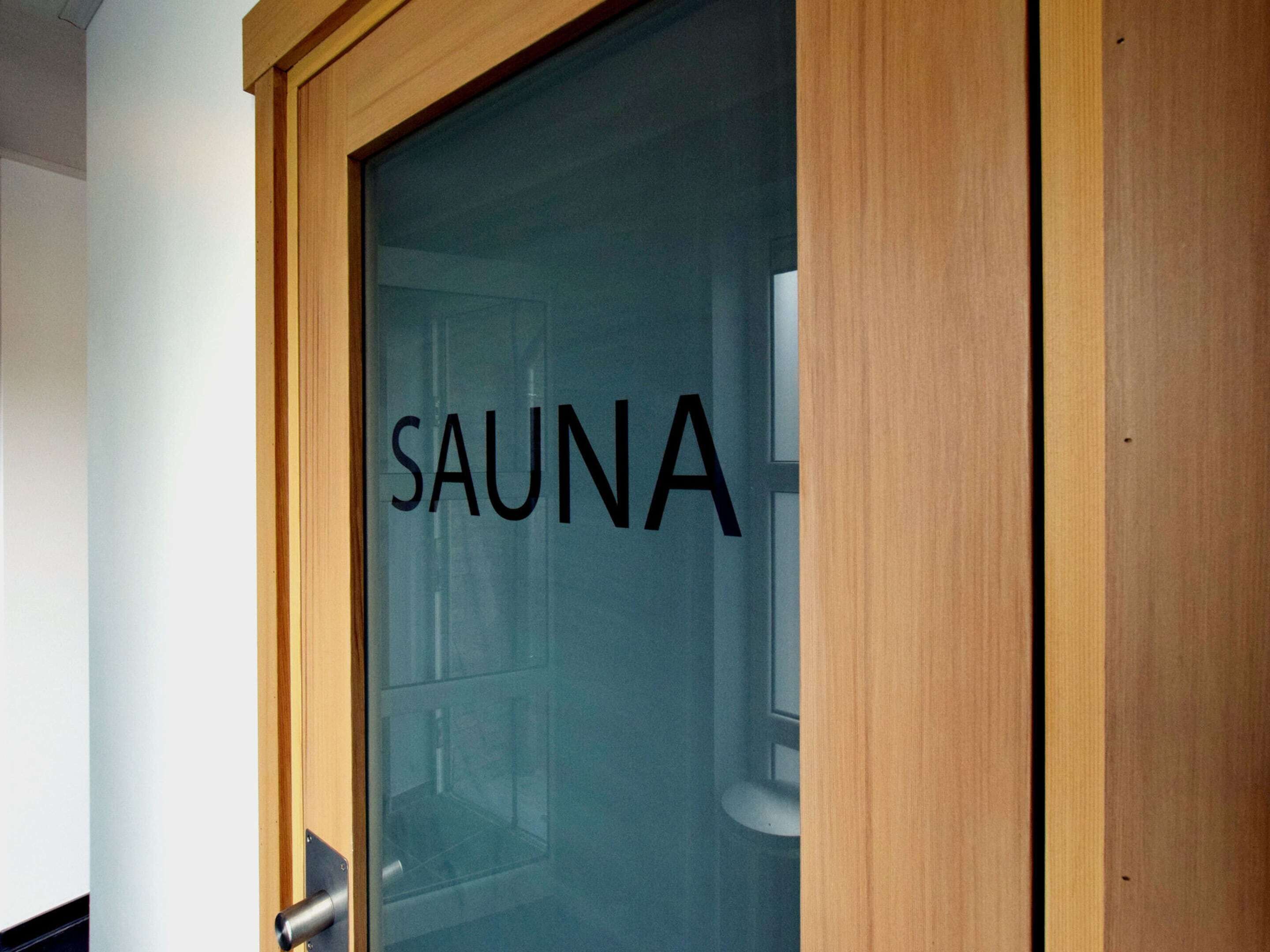 Uma porta com a palavra 'SAUNA', indicando acesso a uma sauna.