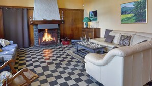 A cozy living room with a fireplace, checkered floor, and a sofa. - Spacious Holiday Home With Private Garden (Houyet)