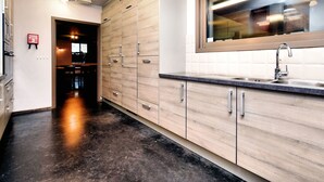 Eine moderne Küche mit Holzausstattung, einer Edelstahl-Spüle und einem Fenster über der Arbeitsfläche.