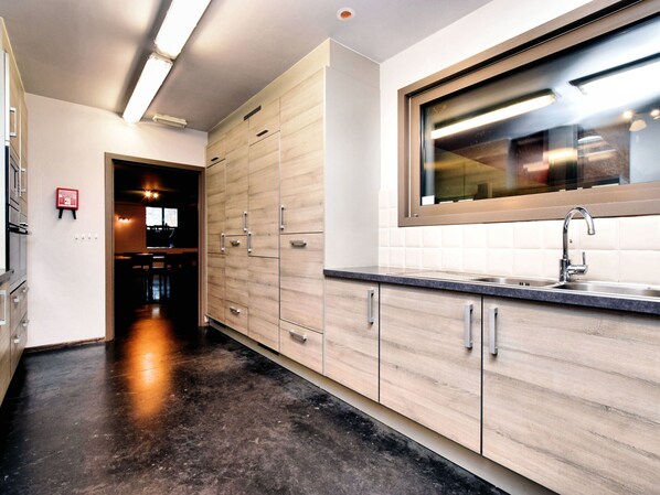 A modern kitchen with wooden cabinets, a stainless steel sink, and a window above the countertop.