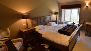 A bedroom with a bed, two bedside tables, a chair, a window, and a lamp. - Holiday Home in Ardennes Near Chimay Abbey (Viroinval)