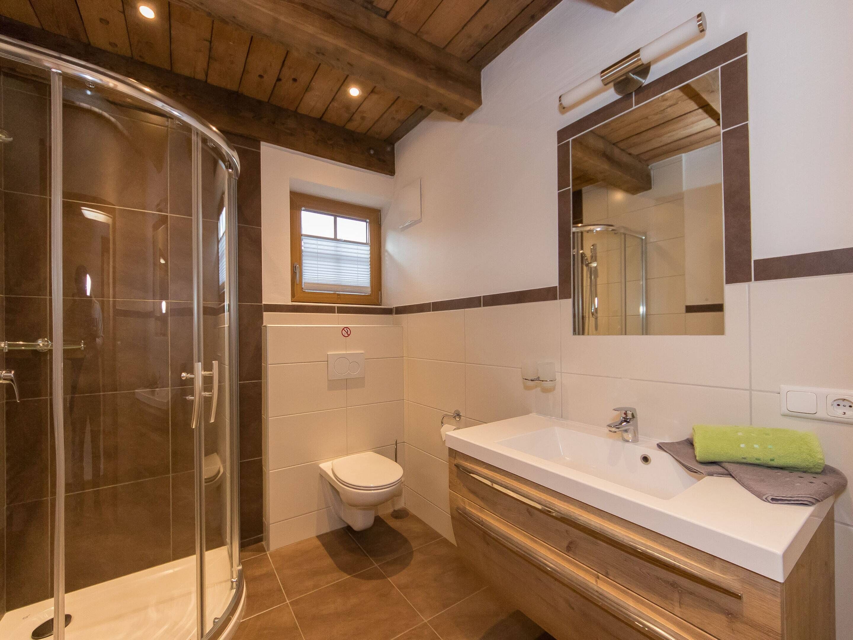 A modern bathroom with a glass-enclosed shower, a toilet, and a vanity with a sink.