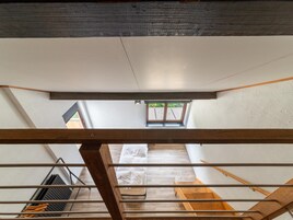 A room with a sloped ceiling, a skylight, and a wooden beam structure.