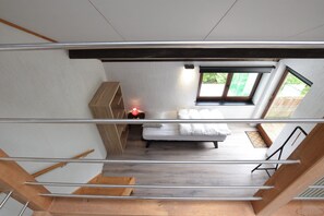 A modern bedroom with a bed, a nightstand, and a window.