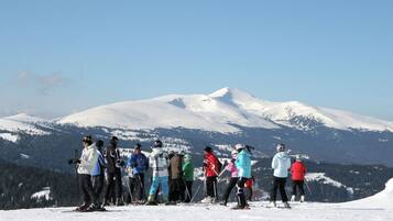 A group of skiers on a snowy mountain with a clear sky.