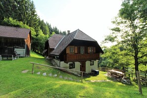 A traditional chalet with a sloped roof, wooden balcony, and a stone pathway leading to the entrance. - Spacious Chalet with Sauna near Ski Area in Wolfsberg (Wolfsberg)