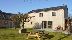 A modern two-story house with a stone facade, a wooden deck, and a large tree in the yard. - Countryside Holiday Home in Theux With Fenced Garden and BBQ (Theux)